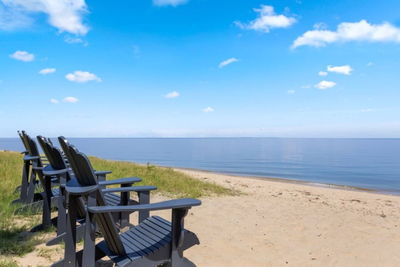 Row of Adirondack chairs on the sandy Chesapeake Bay beach at Plum Point